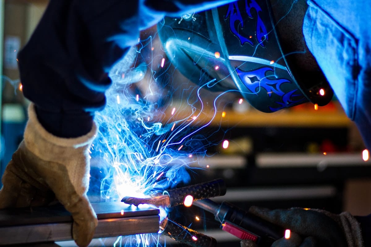 MIG welding: a gas-shielded gun lays a steady blue arc on steel