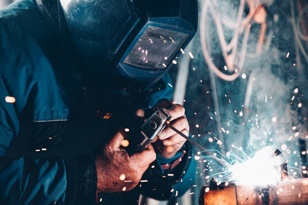 Stick welding a steel pipe with a coated electrode and a bright arc