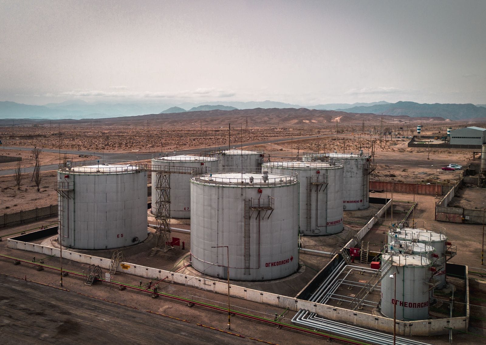 Aerial view of a tank farm with several cylindrical fixed roof storage tanks inside containment berms